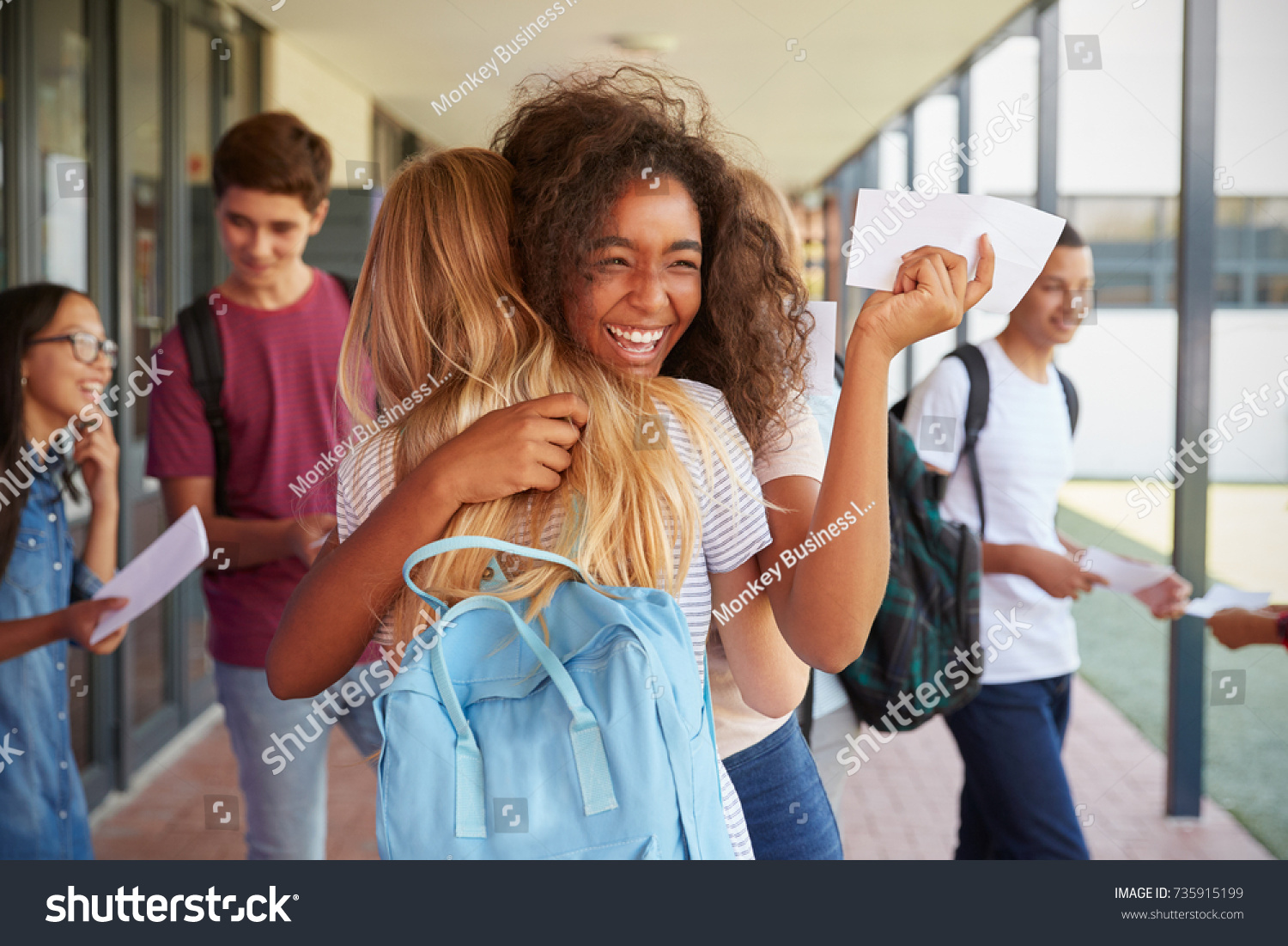 Stock Photo Two Girls Celebrating Exam Results In School Corridor 735915199