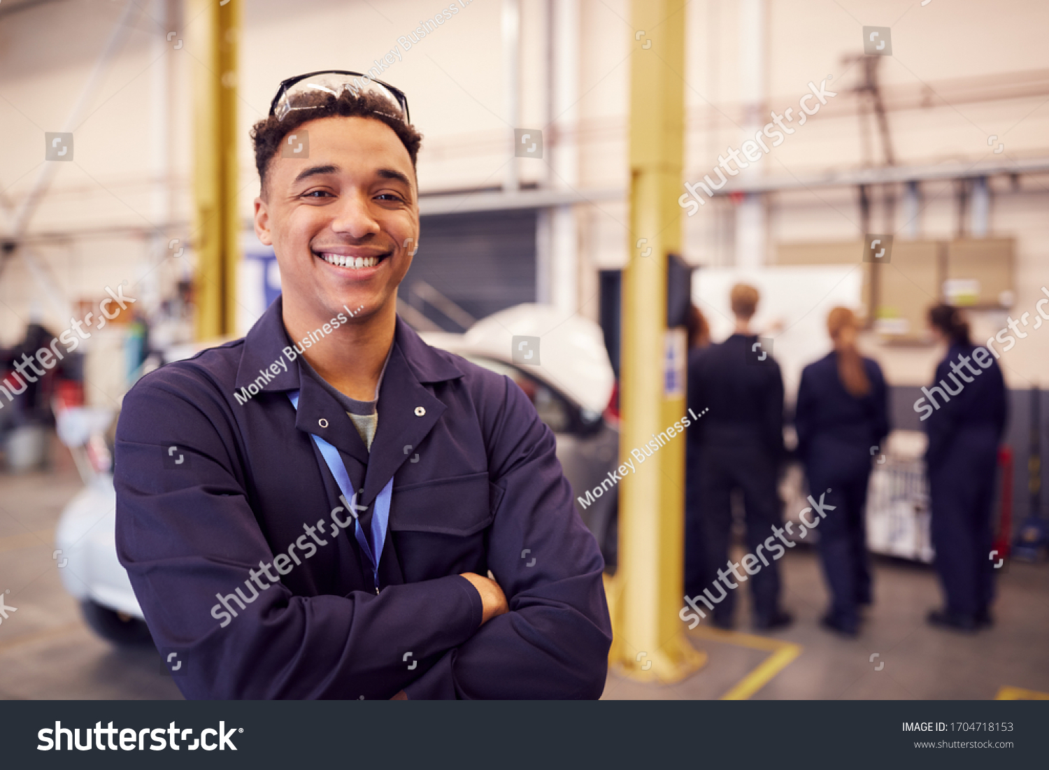 Stock Photo Portrait Of Male Student With Safety Glasses Studying For Auto Mechanic Apprenticeship At College 1704718153